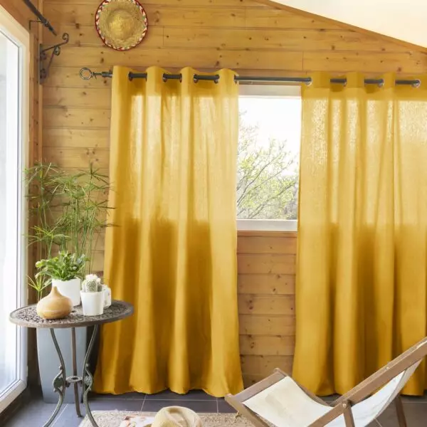 Yellow KALA curtains with silver eyelets at the windows of a conservatory