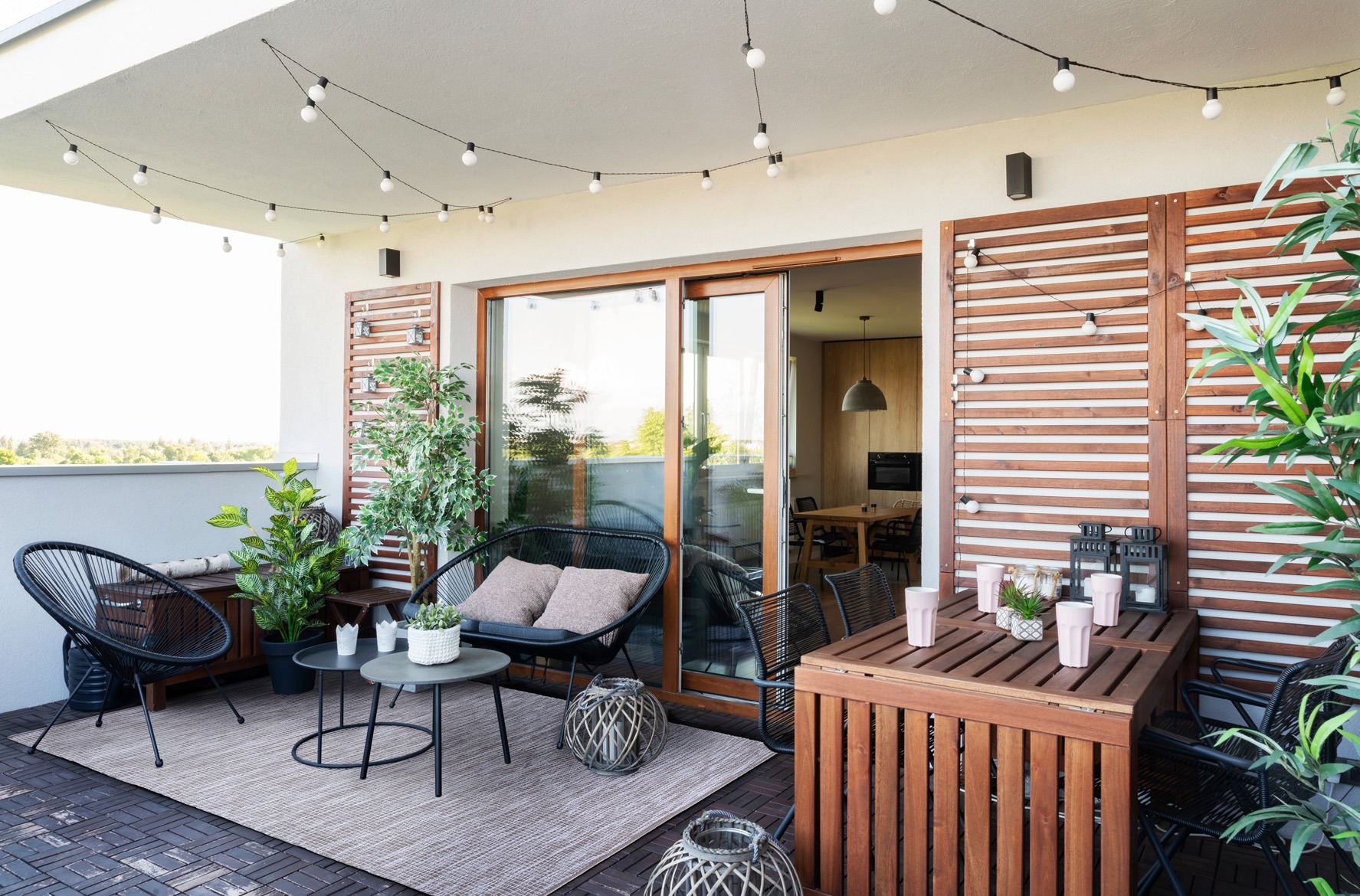 Terrazza,all'esterno,della,casa,con,piante,parete,in,legno,e,tavolo,