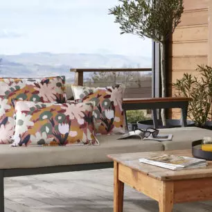 Coussins LÉANE carrés et rectangulaire à grandes fleurs multicolores sur une banquette