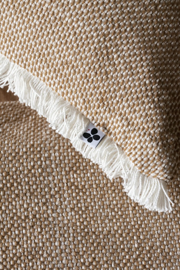 Détail de la texture et des franges du coussin ANTON