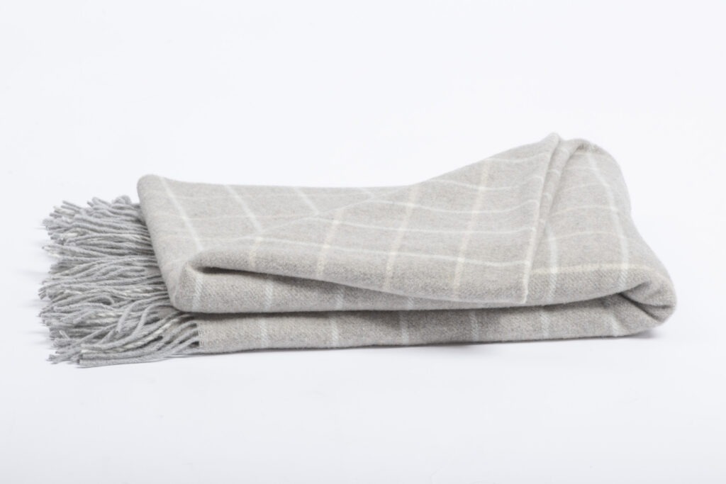 Plaid CAMILLE à carreaux et franges, plié sur fond blanc