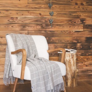 Plaid CAMILLE à carreaux posé sur un fauteuil blanc