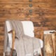 Plaid CÔME à franges drapé sur un fauteuil blanc dans un intérieur en bois