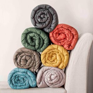 Sette copriletti LAZY trapuntati e arrotolati, vista delle diverse varianti di colore