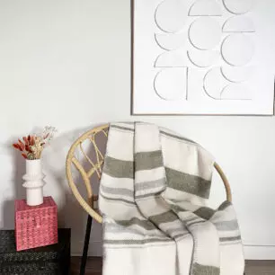 Plaid BERGEN Naturel Sauge à rayures sur un fauteuil en rotin
